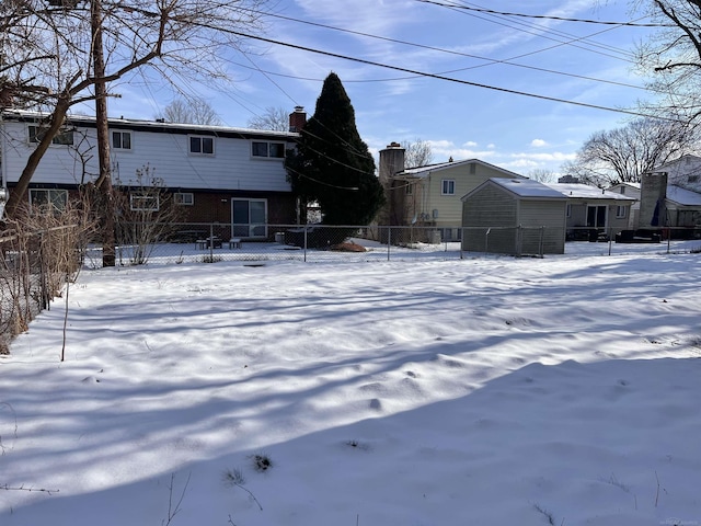 view of snow covered back of property