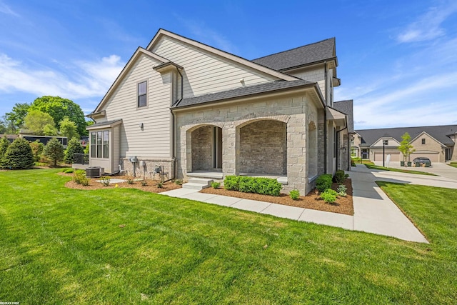 exterior space featuring a garage, central air condition unit, and a front lawn