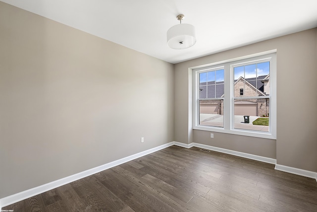 spare room featuring dark wood-type flooring