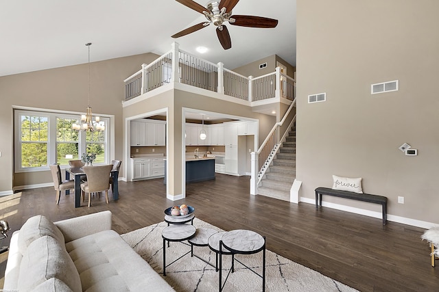 living room with ceiling fan with notable chandelier, high vaulted ceiling, and dark hardwood / wood-style floors