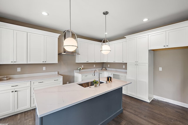 kitchen with a center island with sink, white cabinetry, and pendant lighting