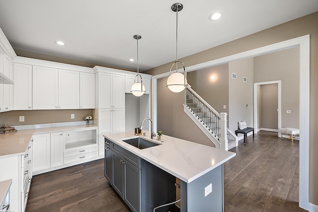 kitchen with white cabinetry, sink, and a center island with sink