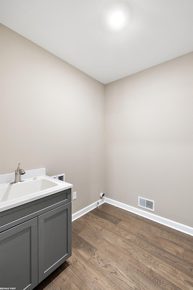 laundry area with dark wood-type flooring, cabinets, washer hookup, and sink