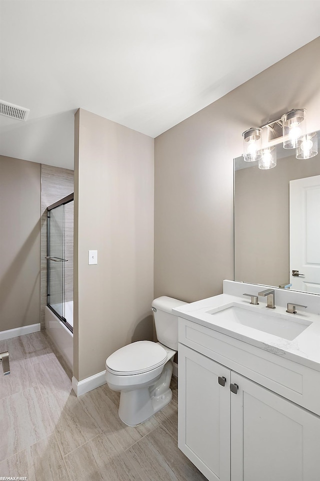 full bathroom featuring vanity, bath / shower combo with glass door, and toilet