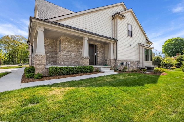 exterior space featuring central air condition unit, covered porch, and a lawn