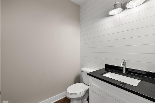 bathroom featuring vanity, wood-type flooring, and toilet