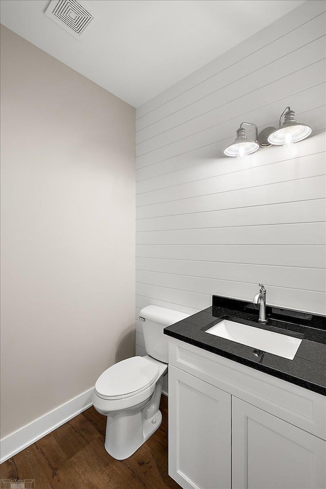 bathroom with wood-type flooring, toilet, and vanity