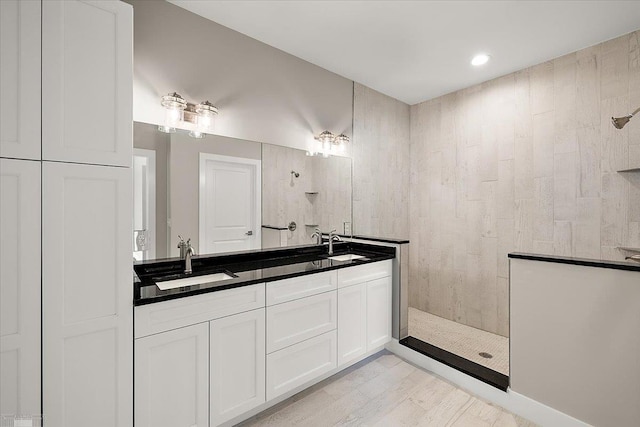 bathroom with vanity and tiled shower