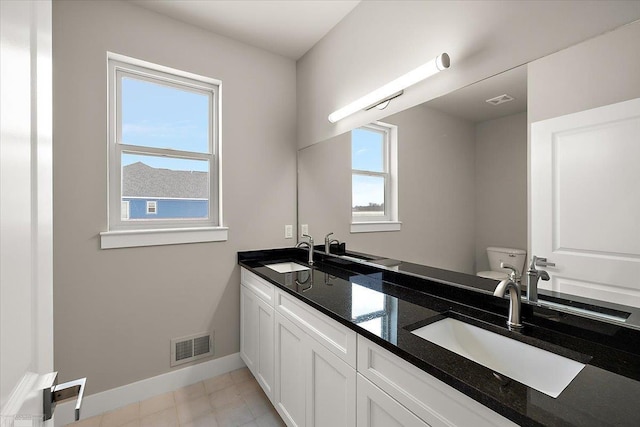 bathroom featuring tile patterned flooring, vanity, and toilet