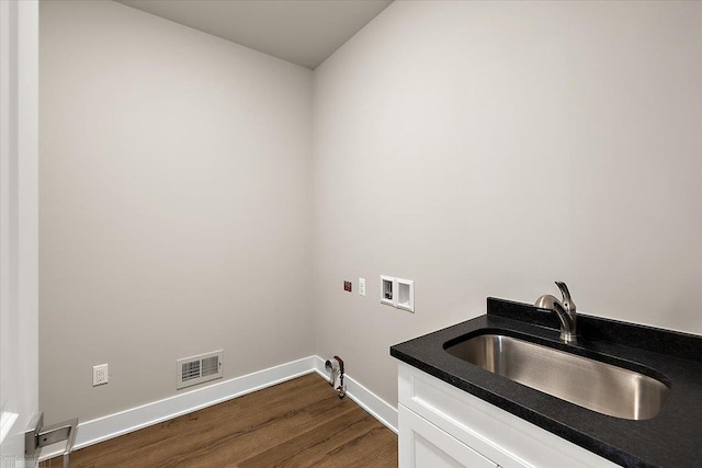 washroom featuring cabinets, sink, washer hookup, and dark hardwood / wood-style flooring