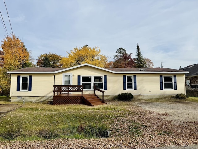 view of front facade with a wooden deck and a front yard