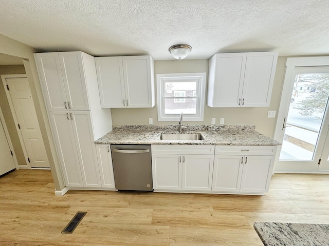 kitchen featuring sink, white cabinetry, dishwasher, light stone countertops, and light hardwood / wood-style floors