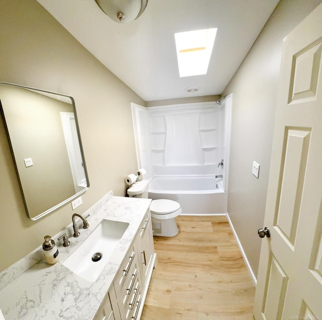 full bathroom featuring toilet, bathing tub / shower combination, a skylight, vanity, and hardwood / wood-style floors