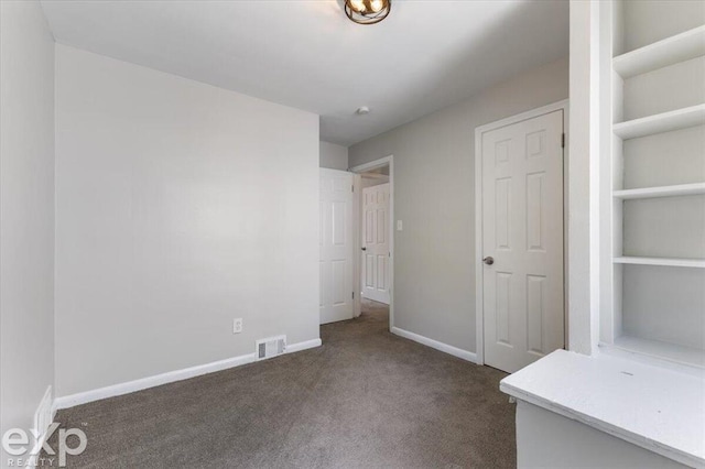 unfurnished bedroom with dark colored carpet