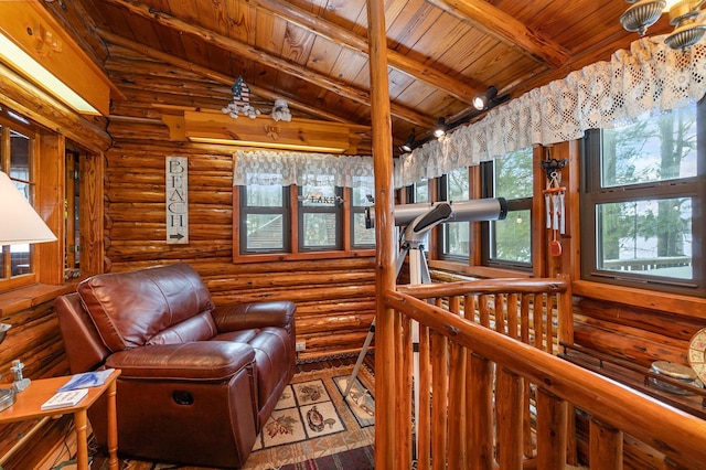 sitting room with vaulted ceiling with beams, rustic walls, and wood ceiling