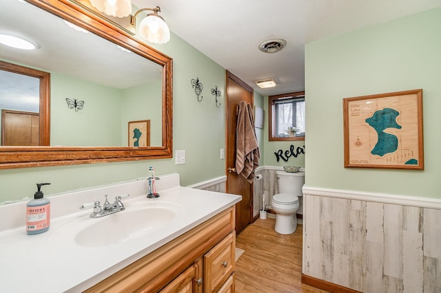 bathroom with hardwood / wood-style flooring, vanity, and toilet