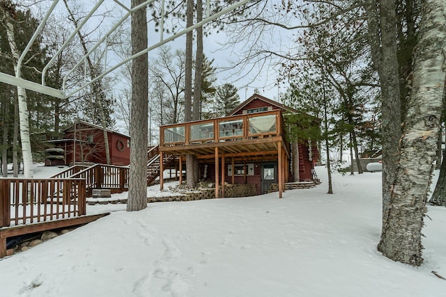 snow covered property with a wooden deck