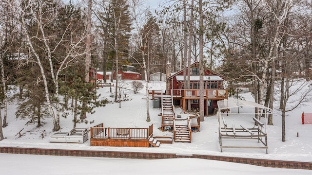 snow covered property with a wooden deck