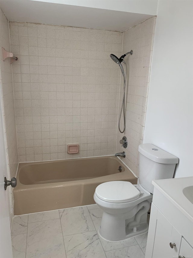 full bathroom featuring vanity, tiled shower / bath, and toilet