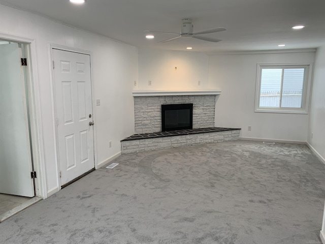 unfurnished living room with ceiling fan, a fireplace, and carpet floors