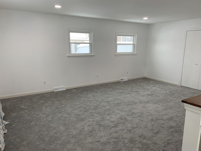 unfurnished room with dark carpet