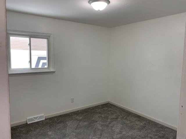 unfurnished room with dark colored carpet