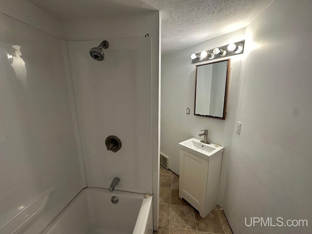 bathroom with vanity, tub / shower combination, and a textured ceiling