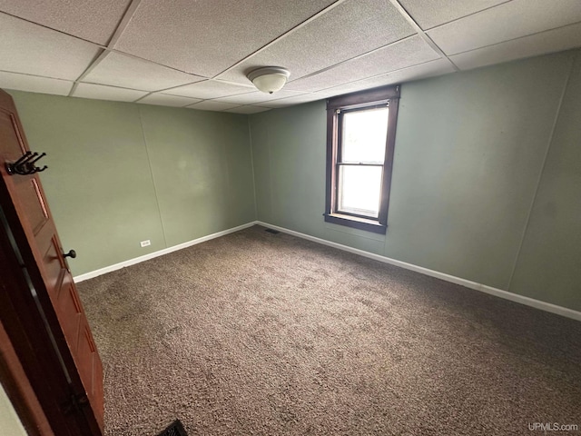 spare room featuring a drop ceiling and carpet