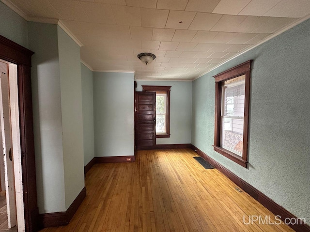 hallway featuring ornamental molding and hardwood / wood-style floors