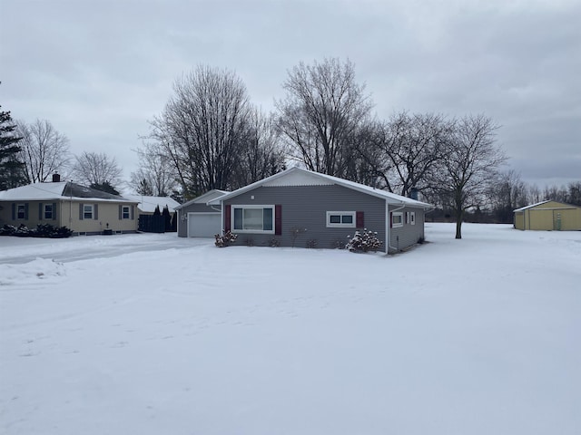 snow covered property with a garage