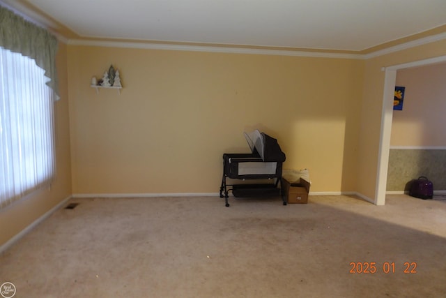 unfurnished room with ornamental molding, a healthy amount of sunlight, and carpet flooring