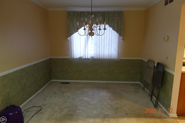 spare room with ornamental molding, carpet flooring, and a chandelier