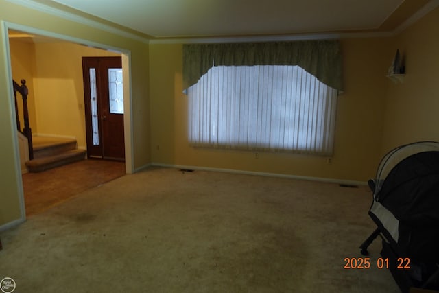 carpeted entrance foyer featuring crown molding