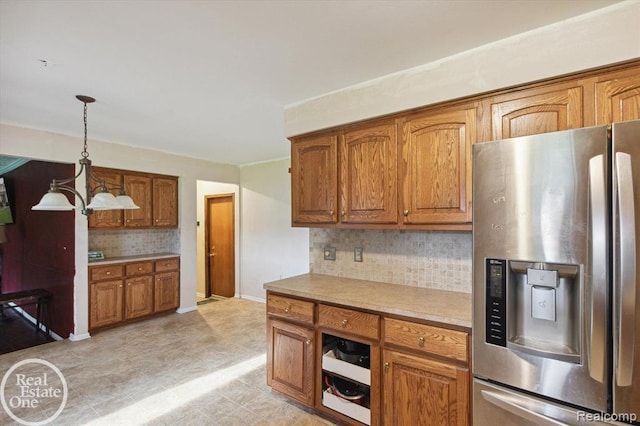 kitchen featuring tasteful backsplash, decorative light fixtures, stainless steel fridge with ice dispenser, and a notable chandelier