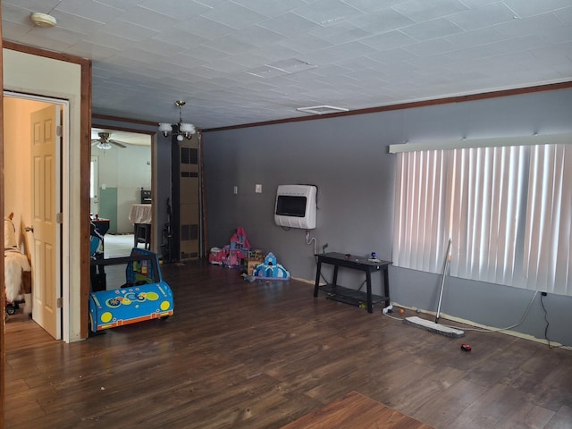 recreation room with heating unit, crown molding, and dark hardwood / wood-style flooring