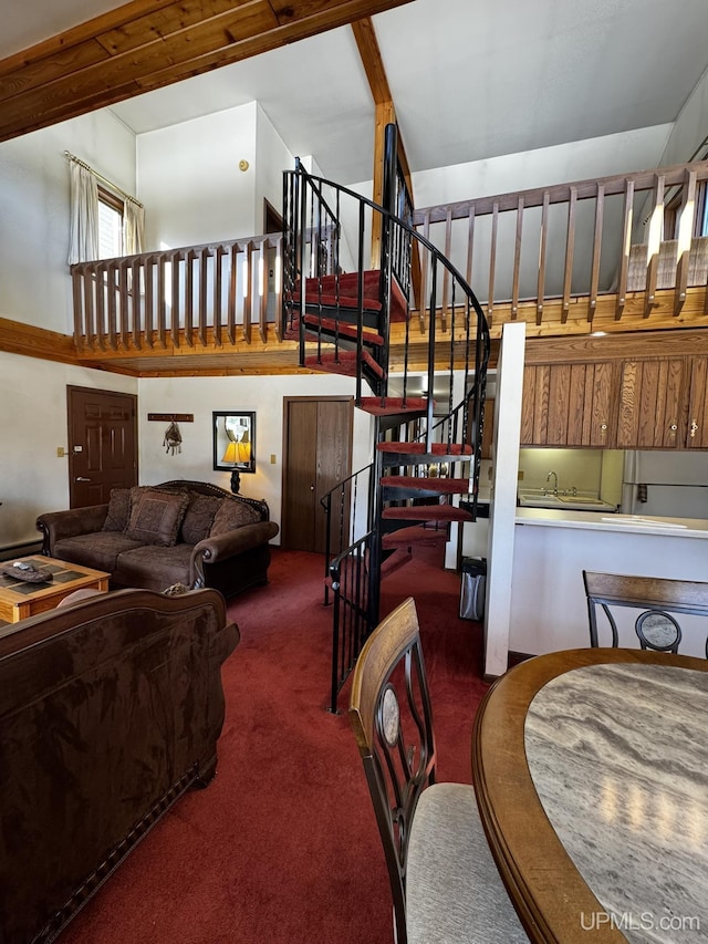 living room with a high ceiling and dark colored carpet