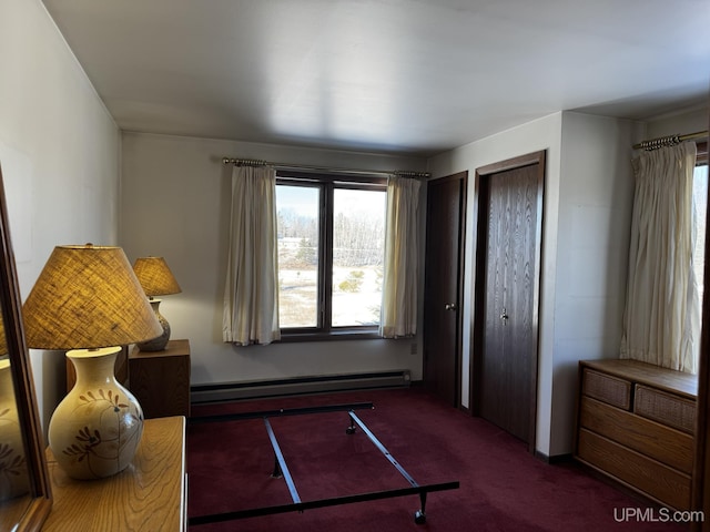 bedroom featuring dark carpet, multiple closets, and baseboard heating