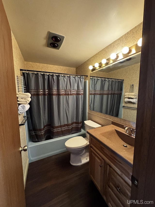 full bathroom with shower / bathtub combination with curtain, vanity, wood-type flooring, and toilet