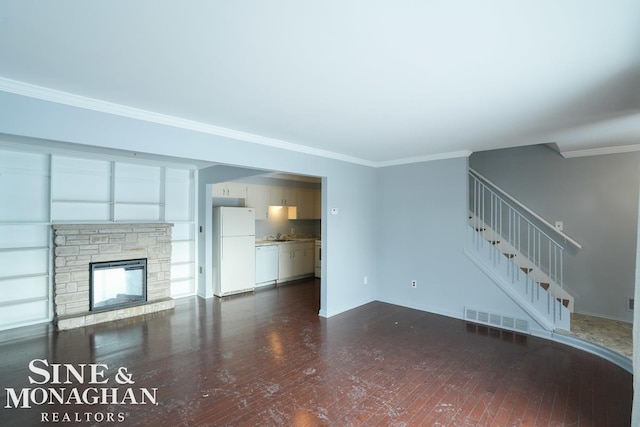 unfurnished living room featuring ornamental molding and a stone fireplace