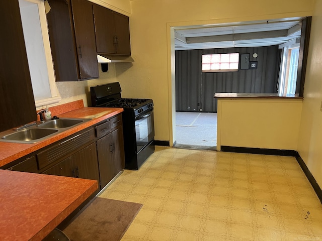 kitchen with dark brown cabinetry, sink, and gas stove