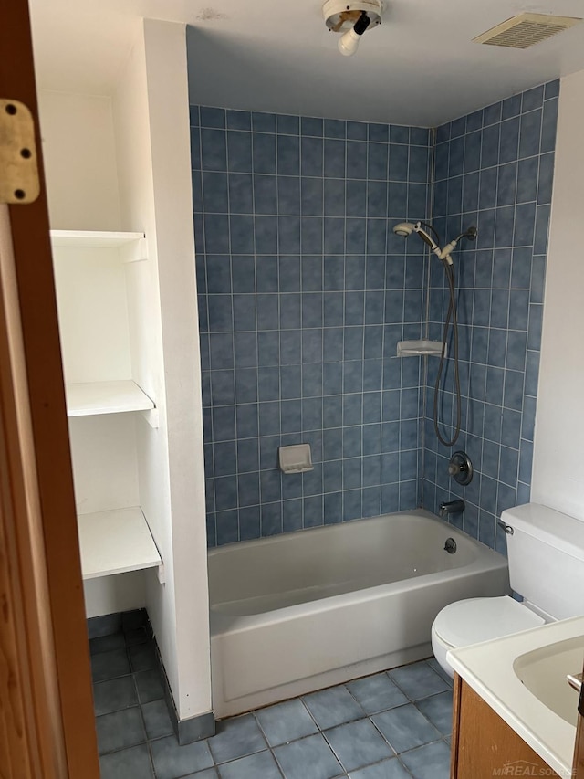 full bathroom featuring tile patterned flooring, vanity, tiled shower / bath combo, and toilet