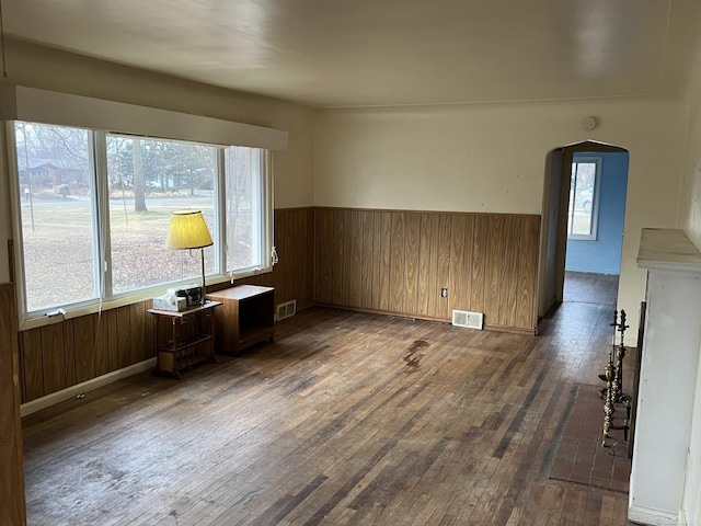 interior space with dark hardwood / wood-style floors and wooden walls