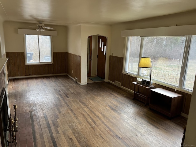 unfurnished living room with dark hardwood / wood-style floors and ceiling fan