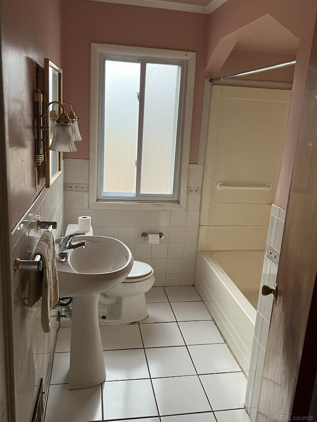 bathroom with plenty of natural light, tile walls, tile patterned floors, and toilet