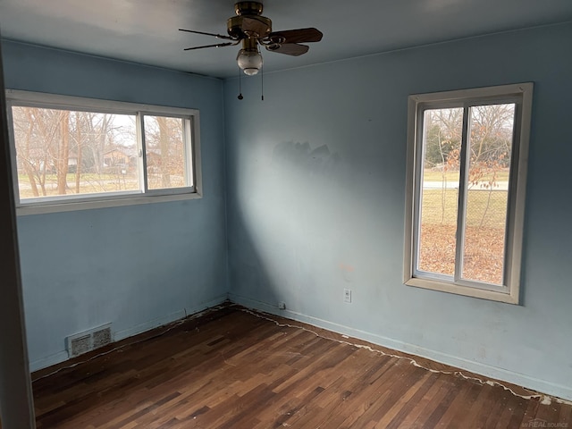 spare room featuring dark wood-type flooring and ceiling fan