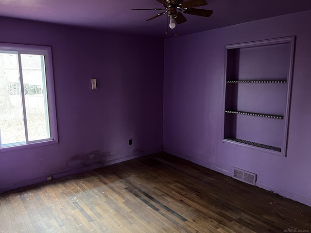 empty room featuring dark hardwood / wood-style flooring and ceiling fan