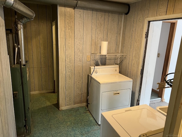 laundry area with washer and clothes dryer and wood walls