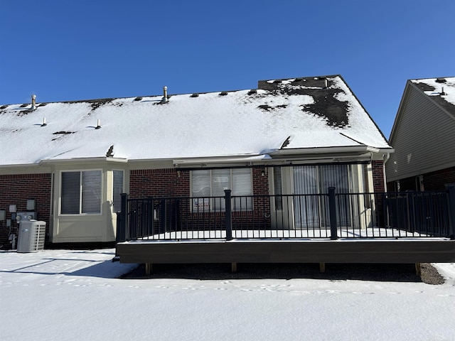 snow covered property with central air condition unit