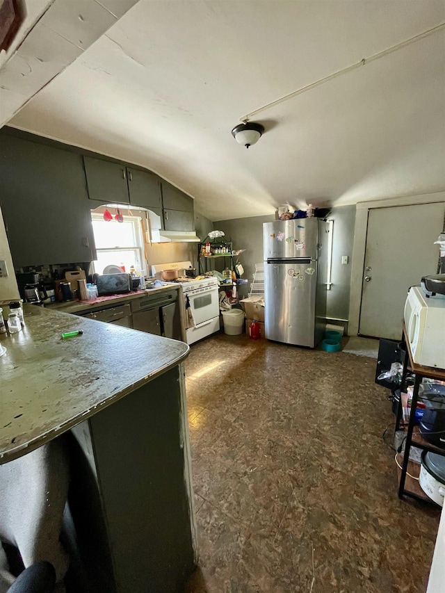 kitchen with stainless steel refrigerator, kitchen peninsula, vaulted ceiling, and gas range gas stove