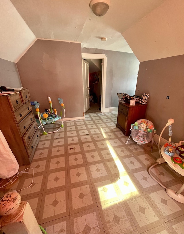 additional living space with light tile patterned flooring and lofted ceiling